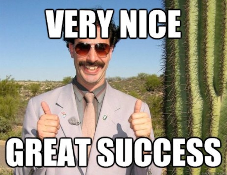 A man with a mustache, wearing a suit and sunglasses, gives two thumbs up. Text over the image reads "Very Nice Great Success". Desert landscape with a tall cactus in the background.